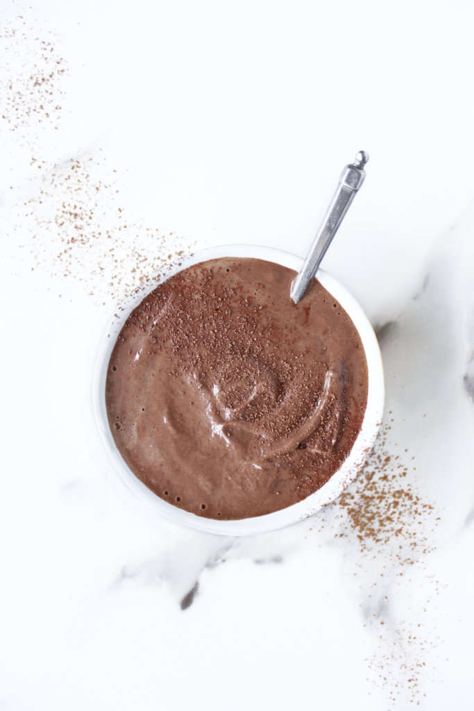 Luscious, thick and creamy, silky vegan chocolate mousse in a bowl on a white marble food photography backdrop