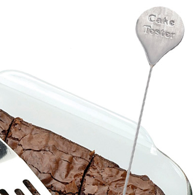 Silver cake tester tool in chocolate brownie cake