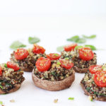 Spinach and quinoa stuffed mushrooms with roasted tomatoes, walnuts and nutritional yeast for a healthy vegan tanksgiving appetizer