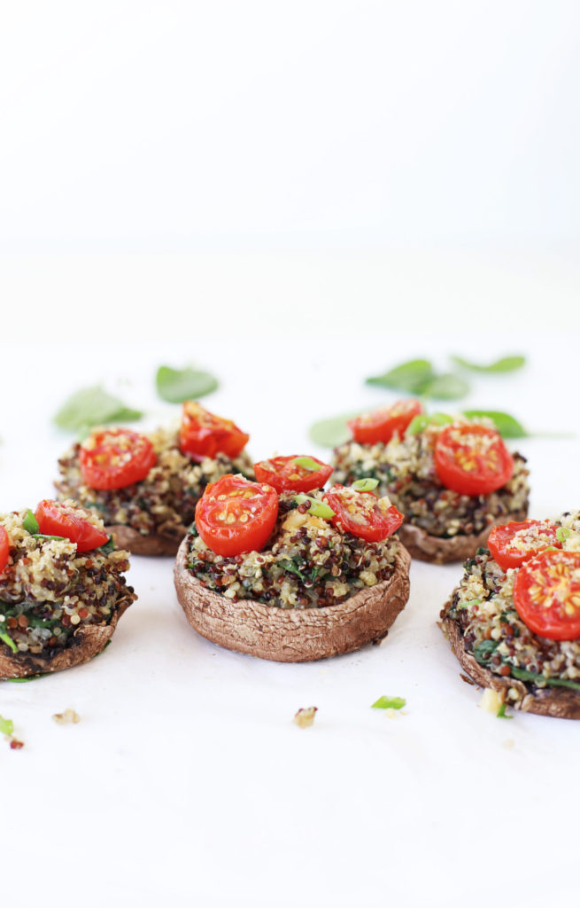 Spinach and quinoa stuffed mushrooms with roasted tomatoes, walnuts and nutritional yeast for a healthy vegan thanksgiving appetizer