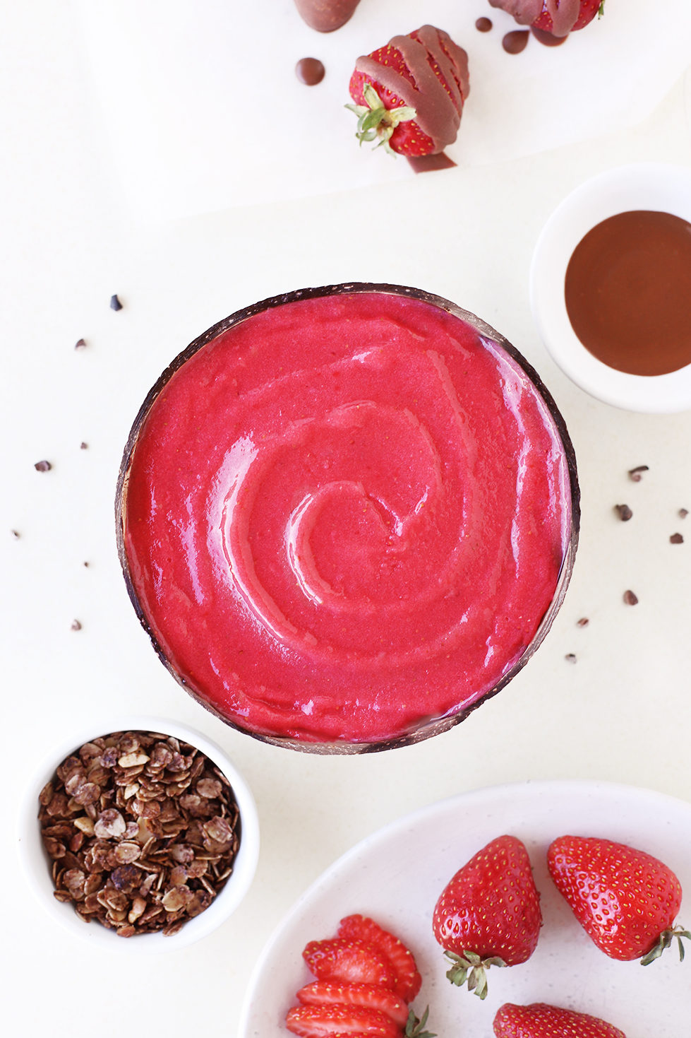 Healthy strawberry smoothie bowl with chocolate sauce, granola and strawberries in a sustainable coconut bowl food styling and photography