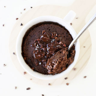 Gluten free vegan chocolate cake in a mug made in the mircowave. A fluffy, gooey, decadent refined sugar free chocolate with sea salt and melted chocolate